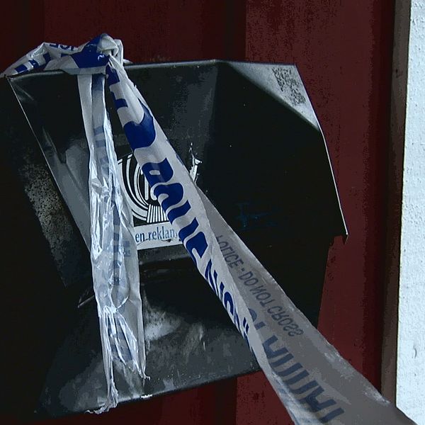 polistejp på en brevlåda vid en avspärrad dörr