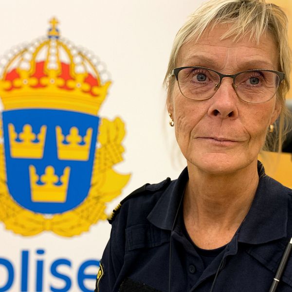 proträttbild på medelålders kvinna i poliskläder, på kontor med polisens symbol på väggen