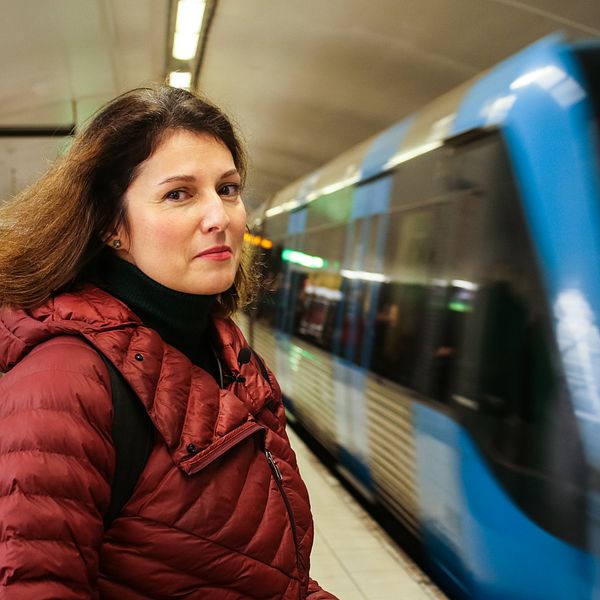 Kvinna framför åkande tunnelbanetåg