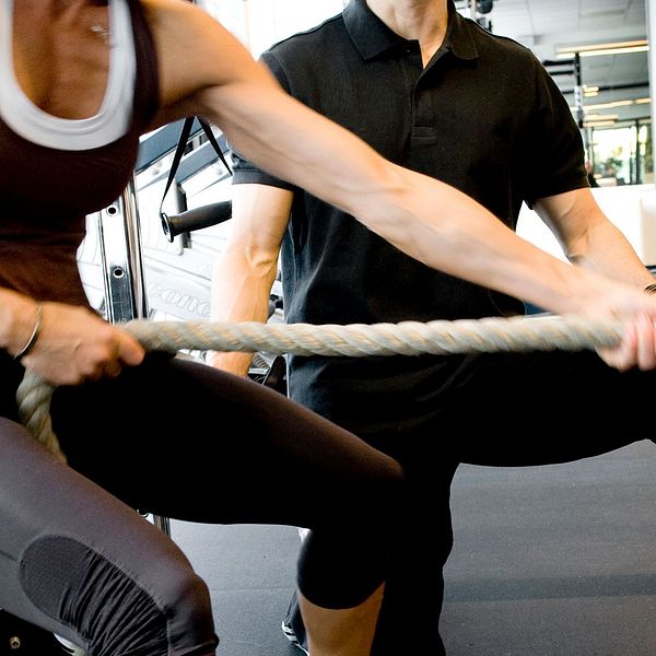 två personer i ett gym som gymar.