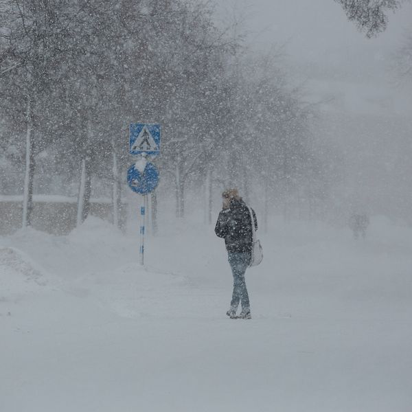 En person går mitt i ett snöoväder