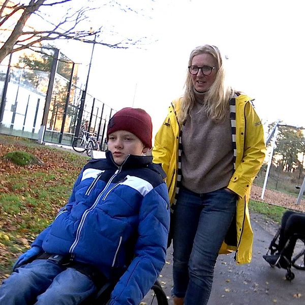 Mamma Anna går bakom Leo som kör rullstol.