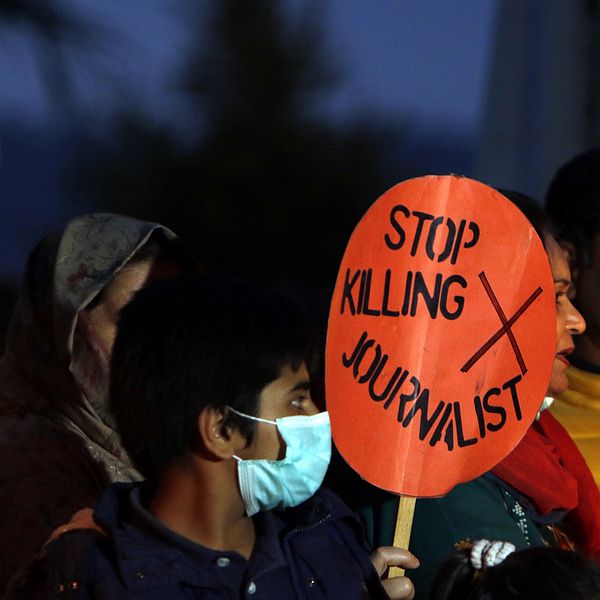 Vuxna och barn protesterar. Skylt med texten ”Stop killing journalist” syns.