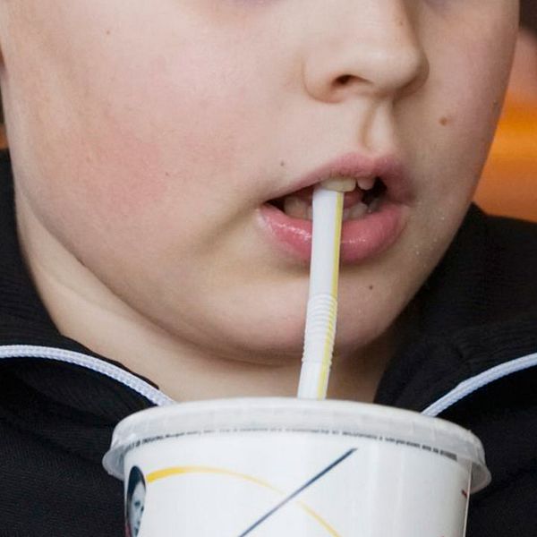 En pojke dricker ur ett sugrör