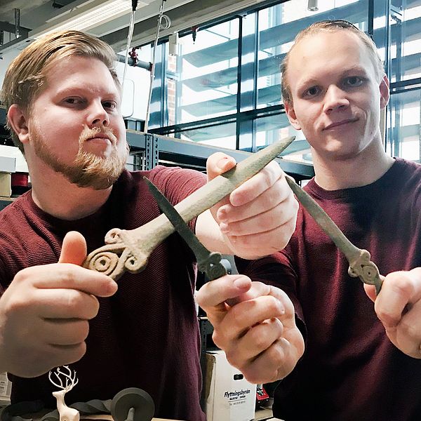 Joakim Wahlberg och Tim Malmgren håller upp knivar som de tillverkat i sin 3D-skrivare, som skapat exakta kopior av fynd från bronsåldern