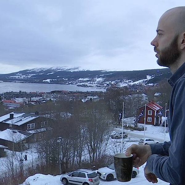 en man på balkong blickar ut över Åre by och Åresjön