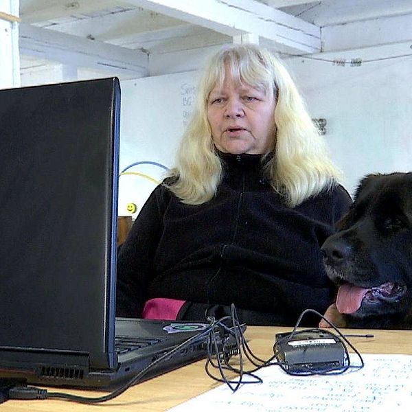 Pirkko Andersson och hunden Bim framför datorn