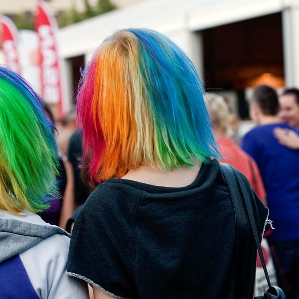 Två personer som färgat sitt hår i regnbågsfärger.