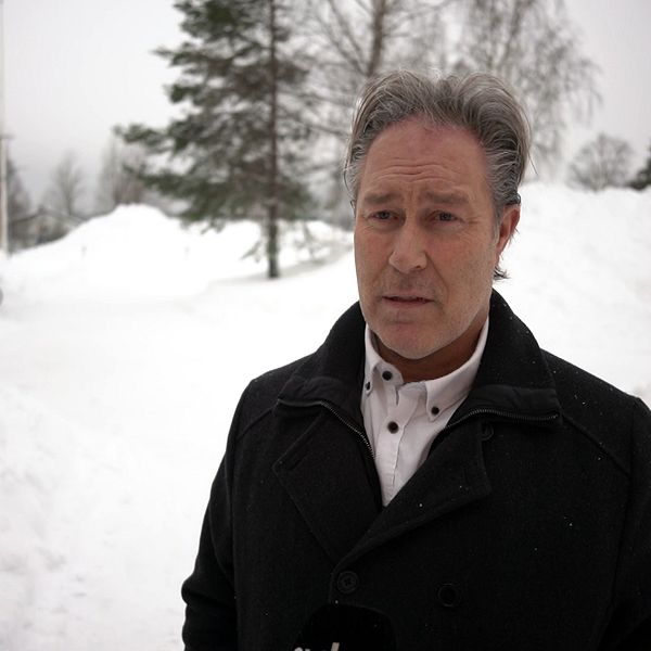 En man i grå rock intervjuas i snöig miljö