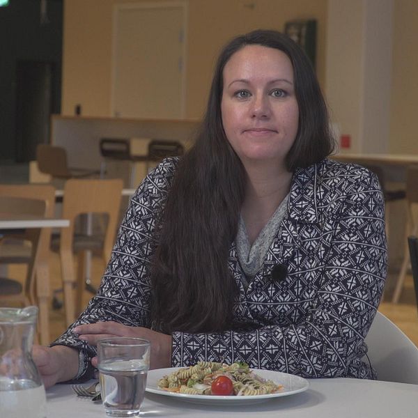 Ulrika Backlund i en matsal med en tallrik, glas och tillbringare framför sig.