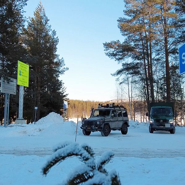 sverigeskylt med militärfordon i bakgrunden