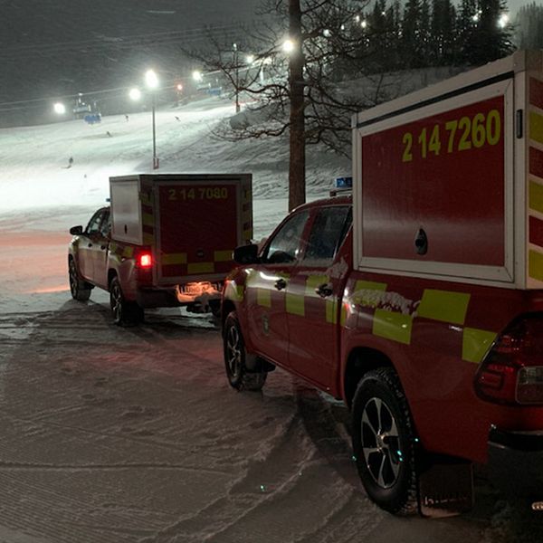 Två bilar från räddningstjänsten står vid foten av en slalombacke.