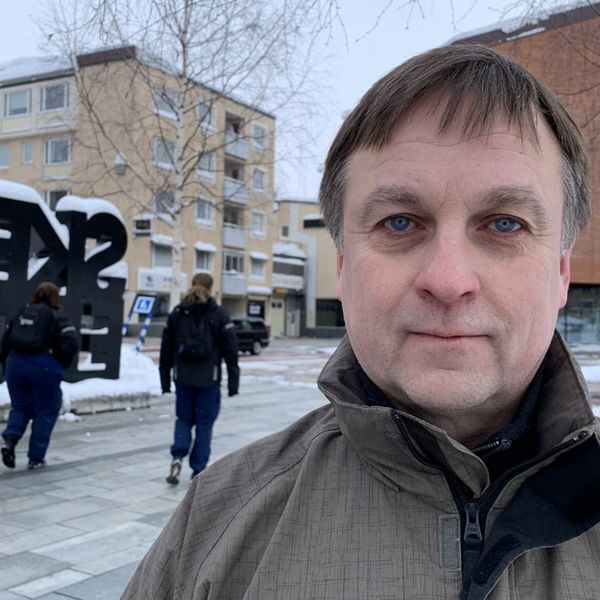 Socialdemokratiskt kommunalråd i Skellefteå, Lorents Burman, kollar in i kameralinsen. I bakgrunden syns baksidan av Skellefteå-bokstäverna på torget i centrum.