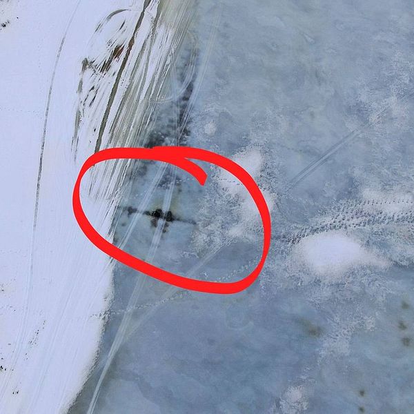 Flygbild över isen på Indalsälven. En vak är inringad med rött på bilden.