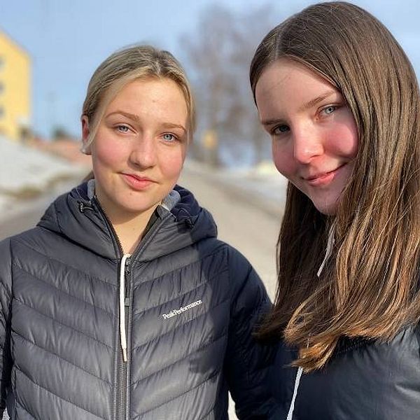 porträtt på två tjejer i vinterjackor på en gata i Sundsvall