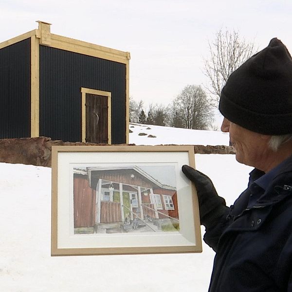 Kurt Eide, chef på Mattila turismanläggning visar upp en målning av gården.