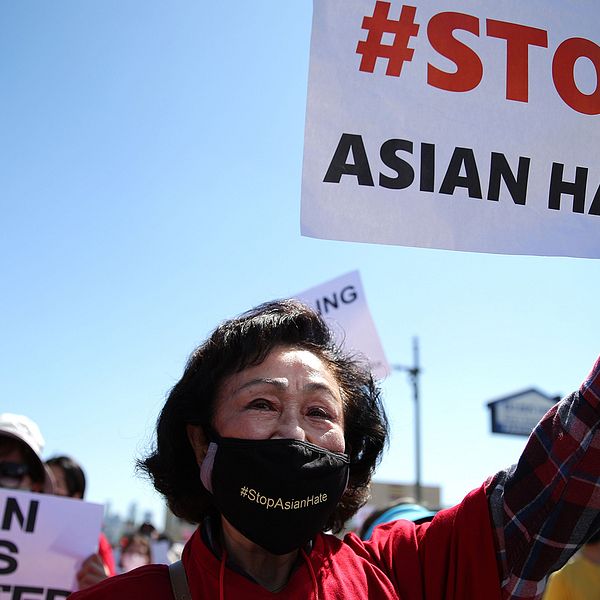 En demonstrant i Koreatown i Los Angeles håller upp en skylt där det står Stop Asian hate