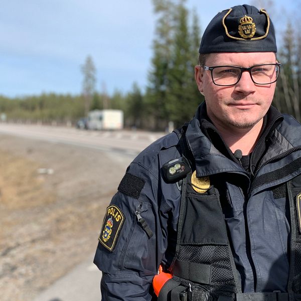 En manlig trafikpolis står vid sidan av motorväg E4 mellan Tönnebro och Gävle.