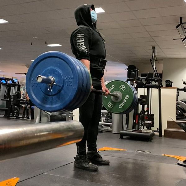 Samuel Johansson lyfter vikter, han väljer att bära munskydd på gym