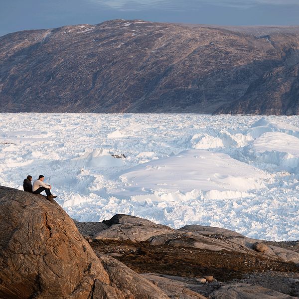 Två forskare vid glaciären Helheim i Grönland.