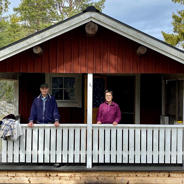 Åke Larsson och dottern Britt-Marie Enberg står på verandan till skogskojan de behöver för att sköta skogen på Brännön.