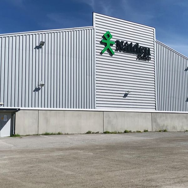 En bild på en grå ishall i Luleå. Hallen står på en parkeringsplats.