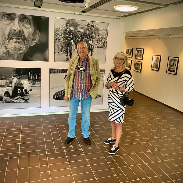 man och kvinna i utställningshall med svartvita foton på väggarna