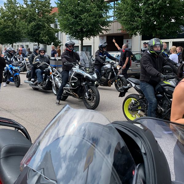 På bilden syns motorcykel-kortegen och en del av de människor som samlats för att se den.