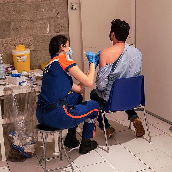 En man vaccineras på ett shoppingcentrum i Paris