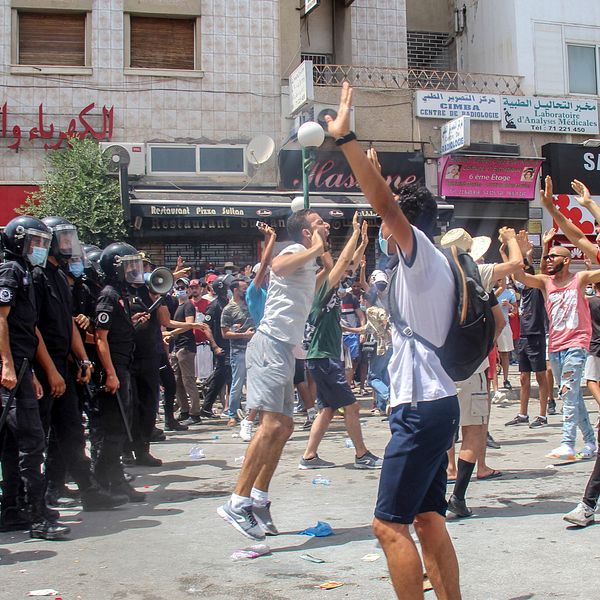 Demonstranter drabbar samman med polis i Tunisiens huvudstad Tunis under söndagen. Våldsamma demonstrationer har brutit ut på flera håll i landet i protest mot landets styre.