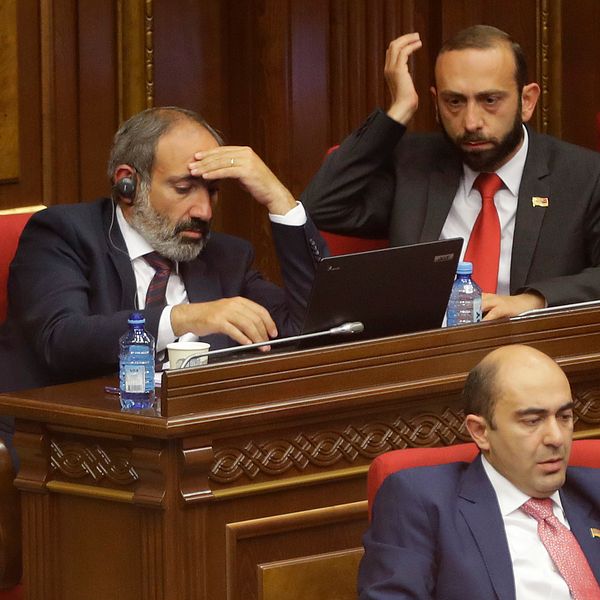 Premiärminister Nikol Pasjinjan, till vänster, tar sig för pannan under ett tidigare sammanträde i parlamentet. Arkivbild.