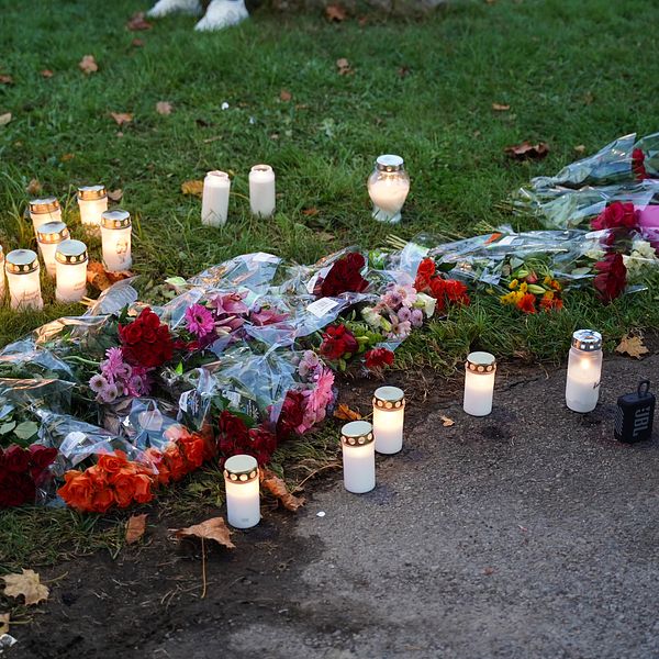 Ljus och blommor på misstänkt mordplats i Växjö.