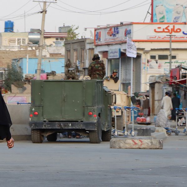 En kvinna passerar en av talibanernas vägspärrar i Kabul, Afghanistan.