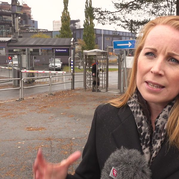 Annie Lööf iklädd en svart kappa utanför grindarna på SSAB i Luleå.