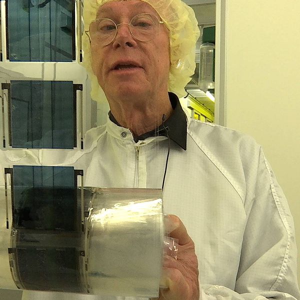 Olle Inganäs tittar på rulle med ljusceller, han är professor emeritus i biomolecular and organic electronics och en av de som 
grundat företaget Epishine