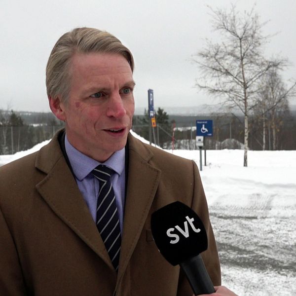 Per Bolund – en medelålders man med slips och kappa – intervjuas på en parkering, lite snö på marken