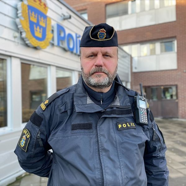 Polis i uniform som står utanför polisstationen i Umeå.
