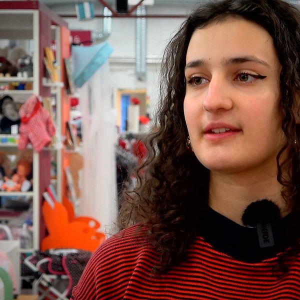 Bild på brunhårig tjej i Erikshjälpens secondhand-butik i Habo.