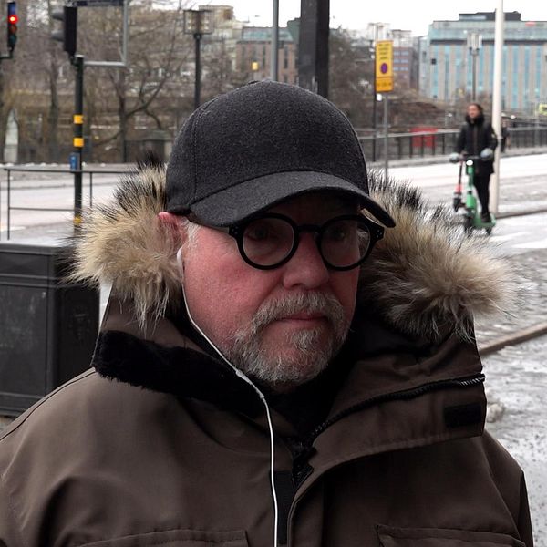 Bild på Johan som står utanför stadshuset i Stockholm.