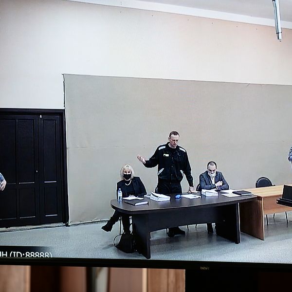 Aleksej Navalnyj (stående i mitten) i domstolen i den straffkoloni där han sedan tidigare avtjänar sitt straff, i Pokrov öster om Moskva.
