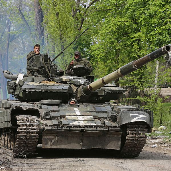 En bild på en rysk tank med två militärer.