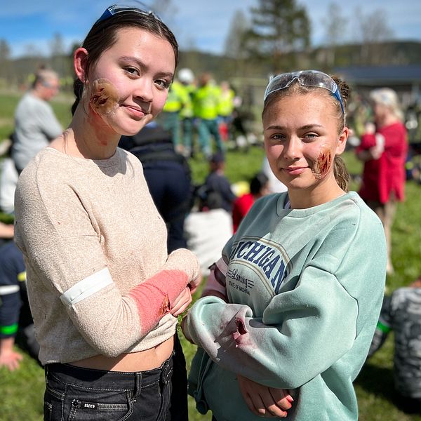 Två unga kvinnor poserar med fejkade sår.