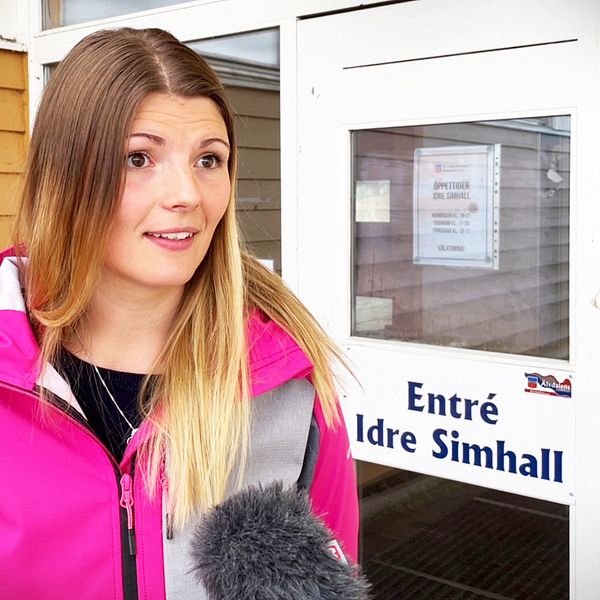 En kvinna står framför dörren till simhallen i Idre.