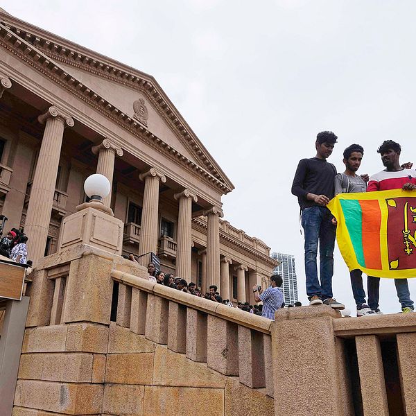 Demonstranter håller en flagga vid president Gotabaya Rajapaksas stormade kontor i huvudstaden Colombo den 11 juli.