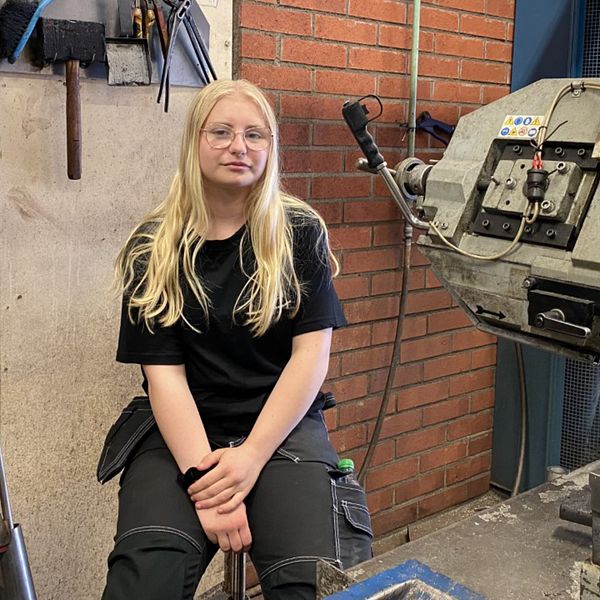 Alexandra Murén sitter på en pall i Säffle industricenters lokaler under sin feriepraktik.