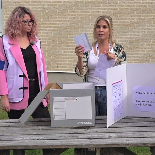 En bild på två kvinnor som visar hur det går till att rösta hemma.