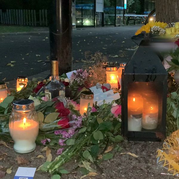 Blommor och ljus på en minnesplats i Halmstad efter det misstänkta knivmordet