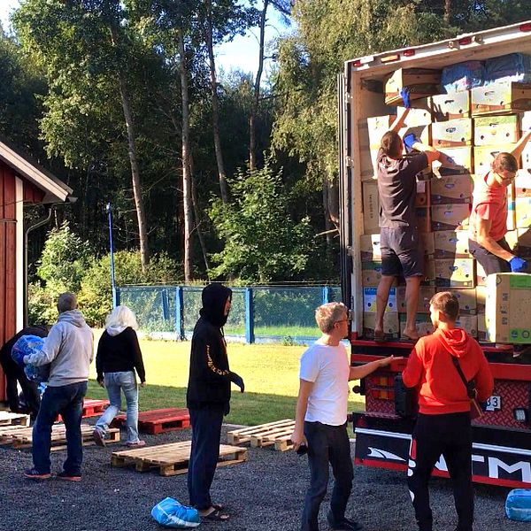 ungdomar i Lutsk lastar av kartonger från lastbilen från Skara