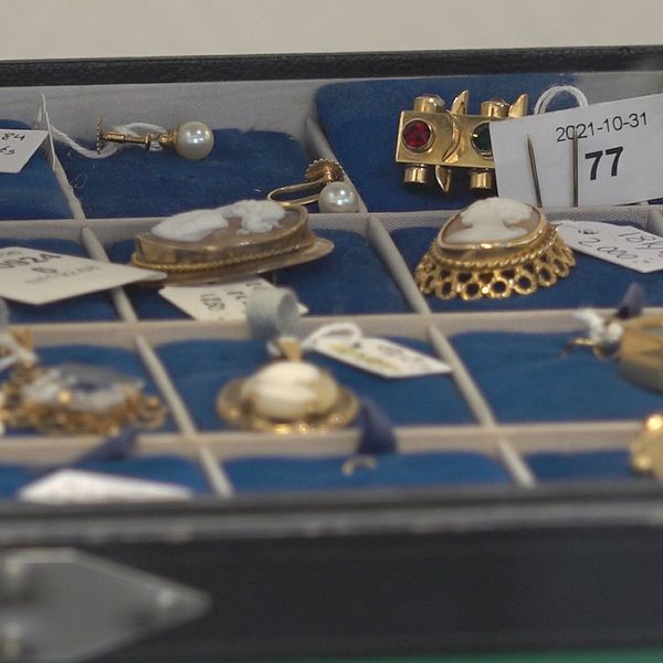 Bild på smycken som ligger i ett smyckesskrin i en pantbank.