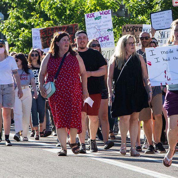 En stor grupp människor med plakat, mest kvinnor, som protesterar mot att rätten till abort har begränsats i USA.